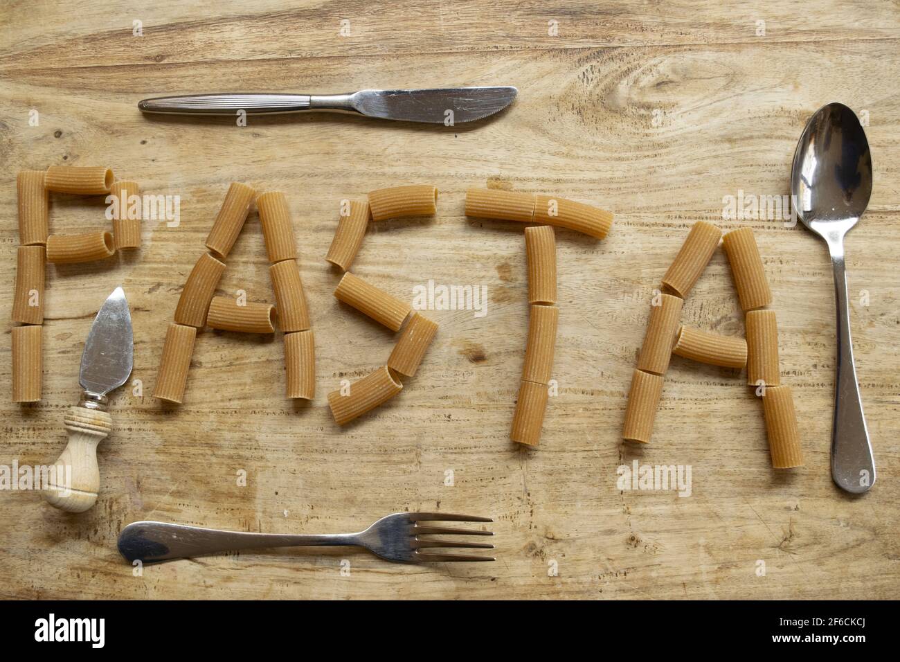 Geschriebene Pasta mit Vollkornrigatoni auf holzverwertbar Stockfoto