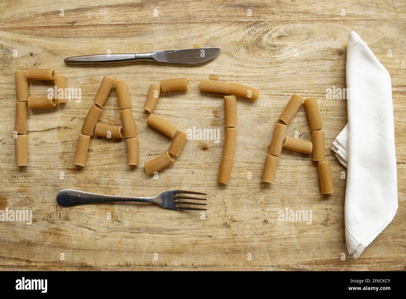 Geschriebene Pasta mit Vollkornrigatoni auf holzverwertbar Stockfoto