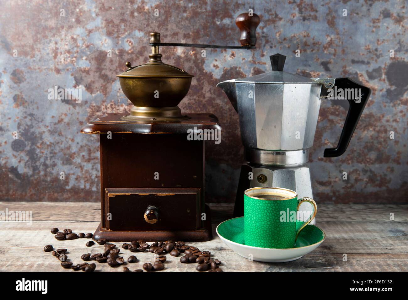 Einfache Standzeit einer manuellen Kaffeebohnenmühle, Kaffeekocher und Demitasse Tasse mit Untertasse Stockfoto
