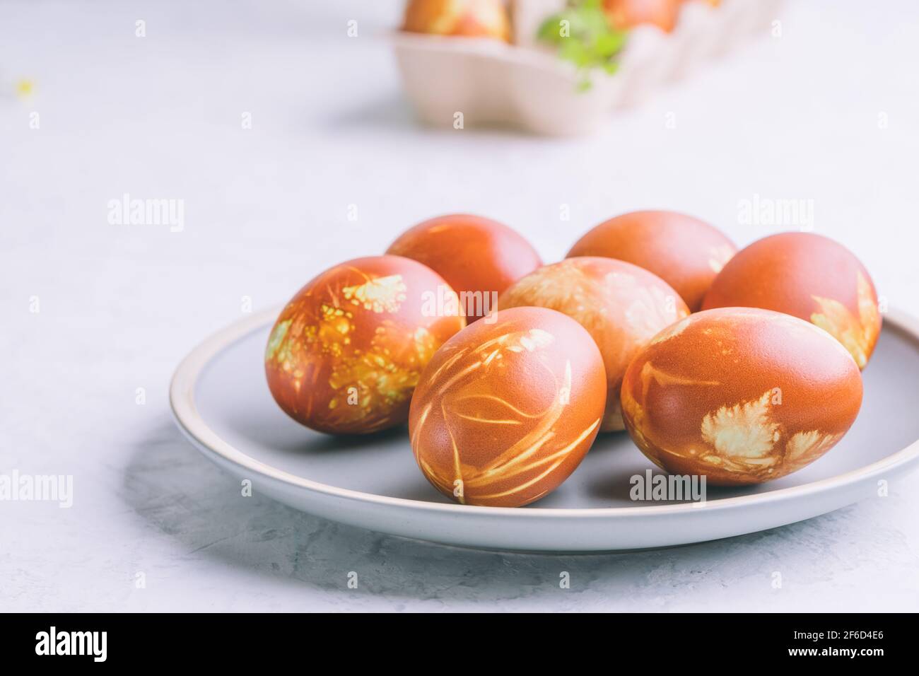 Osterbrunch-Tisch. Natürlich gefärbte Ostereier mit Zwiebelschalen und Frühlingspflanzen, nachhaltiges Wohnen, umweltfreundliches Frühlingsfest Stockfoto