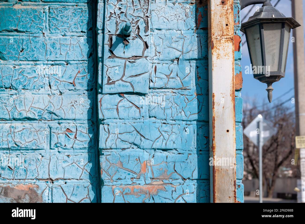 Blaue rissige Farbe auf einer Ziegelwand. Textur der alten rissigen Farbe. Rostetes Metall. Stockfoto