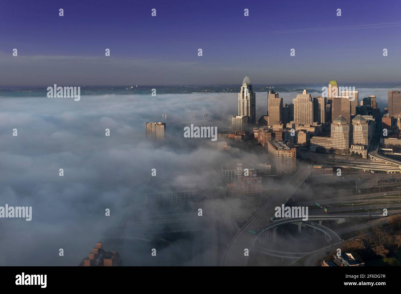 Am frühen Morgen bedeckt Nebel den Ohio River über der Innenstadt von Cincinnati Und Kentucky, während die Sonne Gebäude und Brücken durchleuchtet Die Nebelwolken Stockfoto