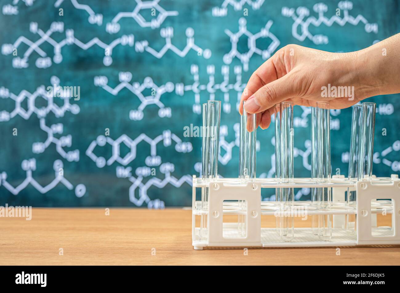 Laborglas mit Tafelhintergrund mit verschiedenen chemischen Formeln. Stockfoto