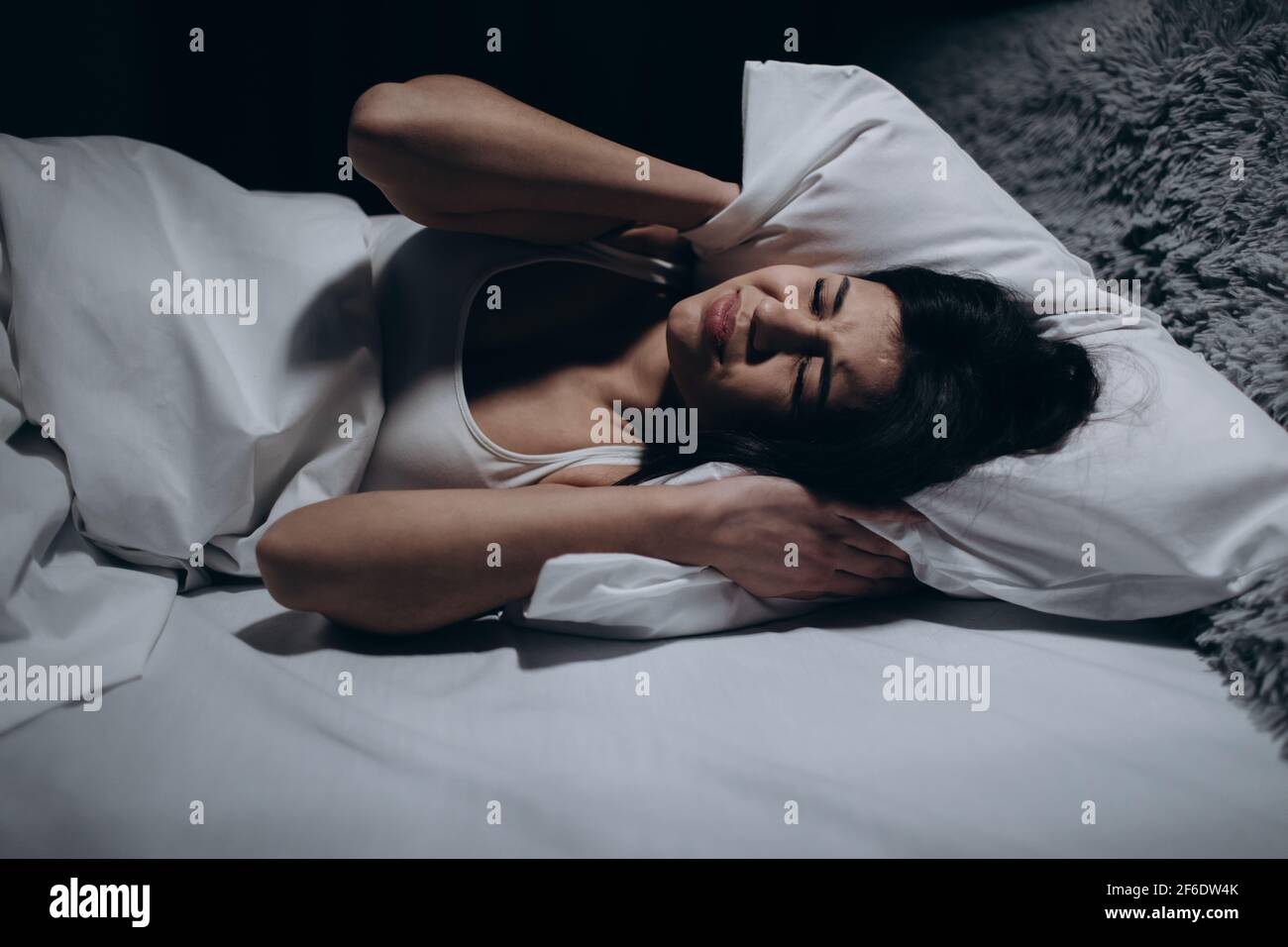 Frau kann nicht schlafen von Lärm Stockfoto