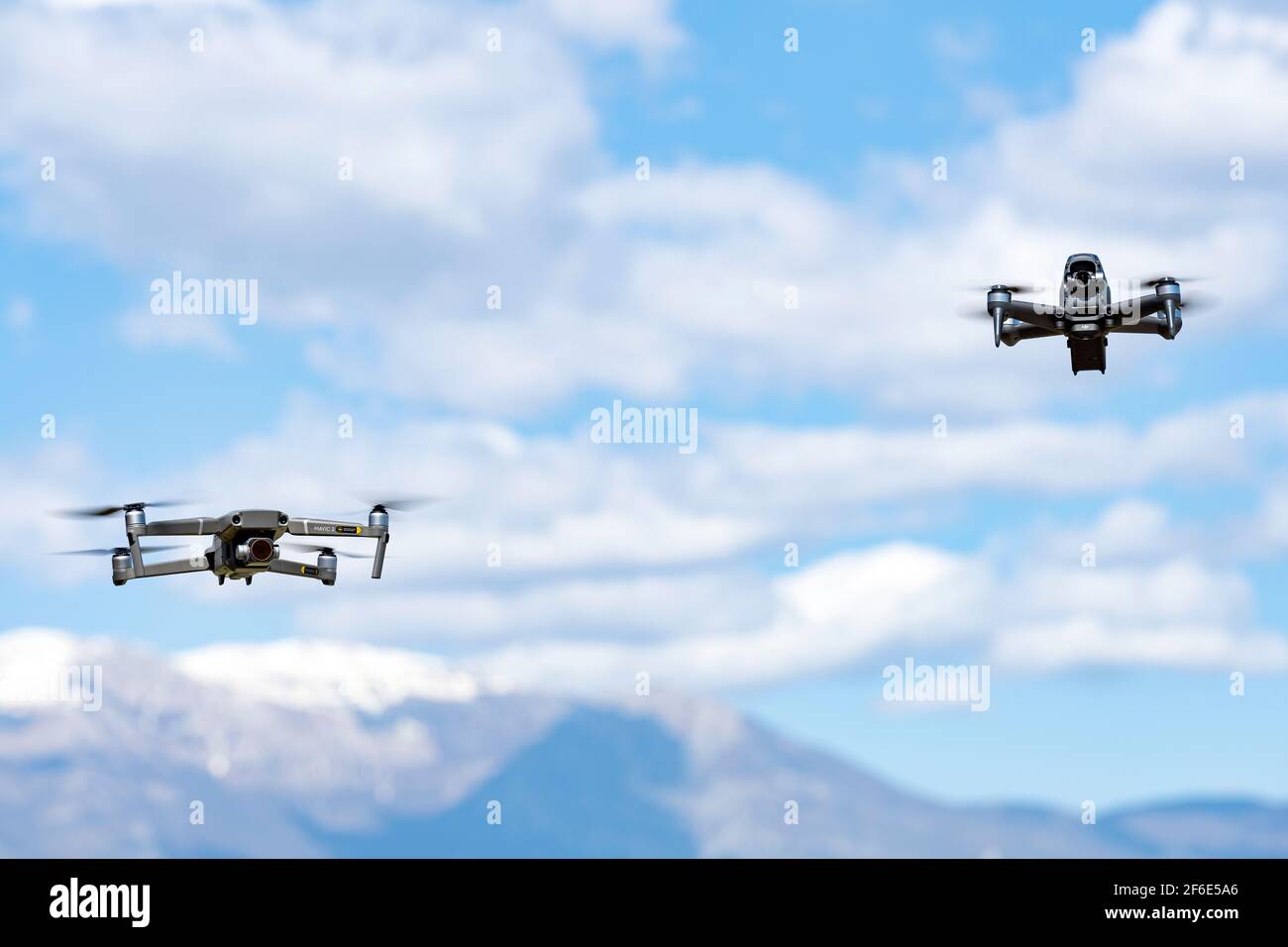 Zwei DJI-Drohnen fliegen an einem sonnigen Tag in der Nähe. DJI FPV ist eine bahnbrechende flugfertige FPV-Drohne. Stockfoto