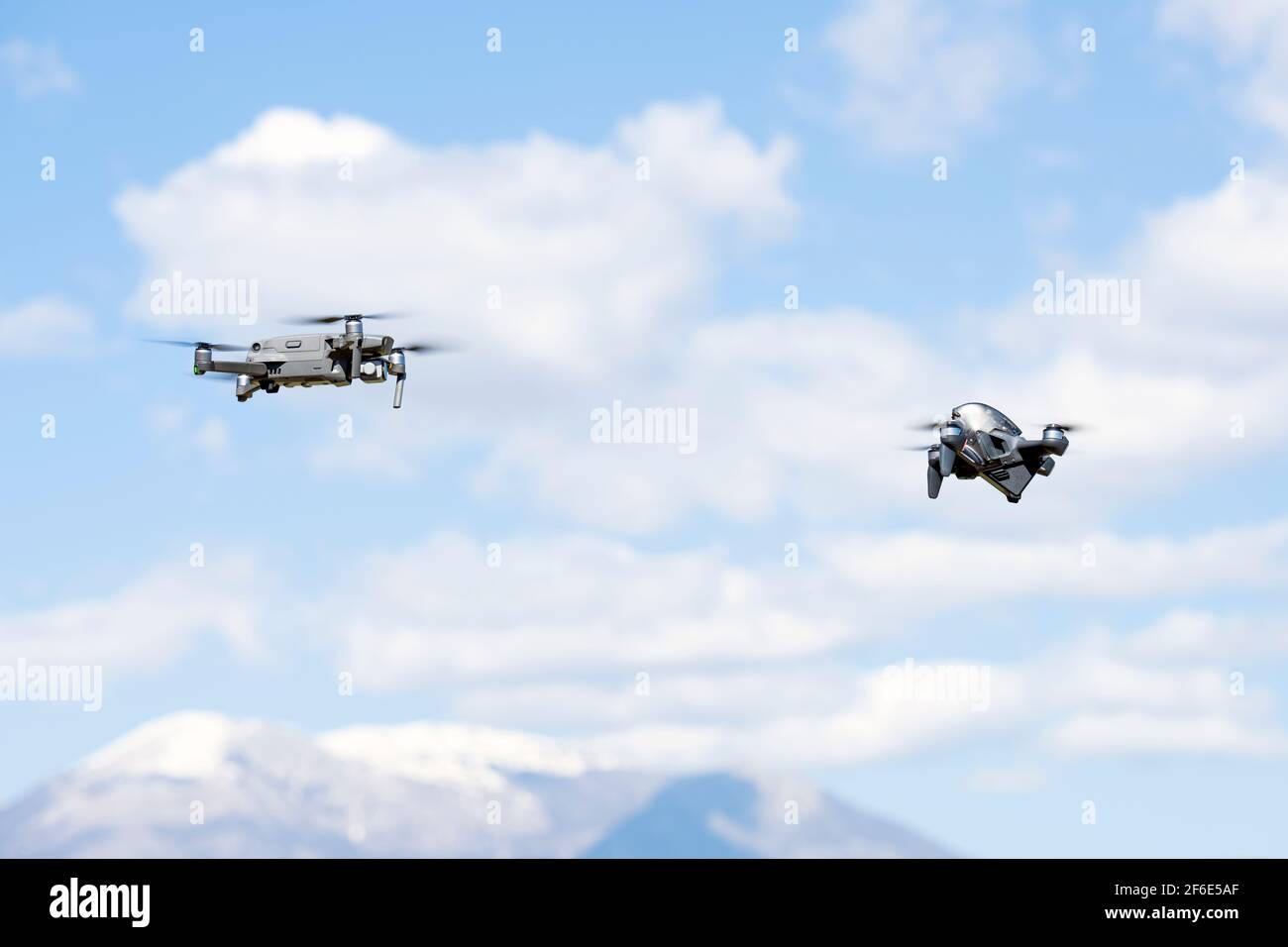 Zwei DJI-Drohnen fliegen an einem sonnigen Tag in der Nähe. DJI FPV ist eine bahnbrechende flugfertige FPV-Drohne. Stockfoto