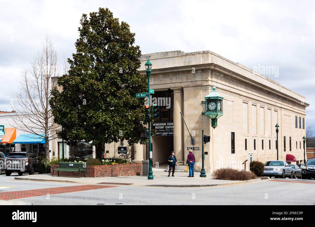 HENDERSONVILLE, NC, USA - 23. MÄRZ 2021: Das Henderson County History Center, an der Main Street. Zwei Frauen an der Ecke. Stockfoto