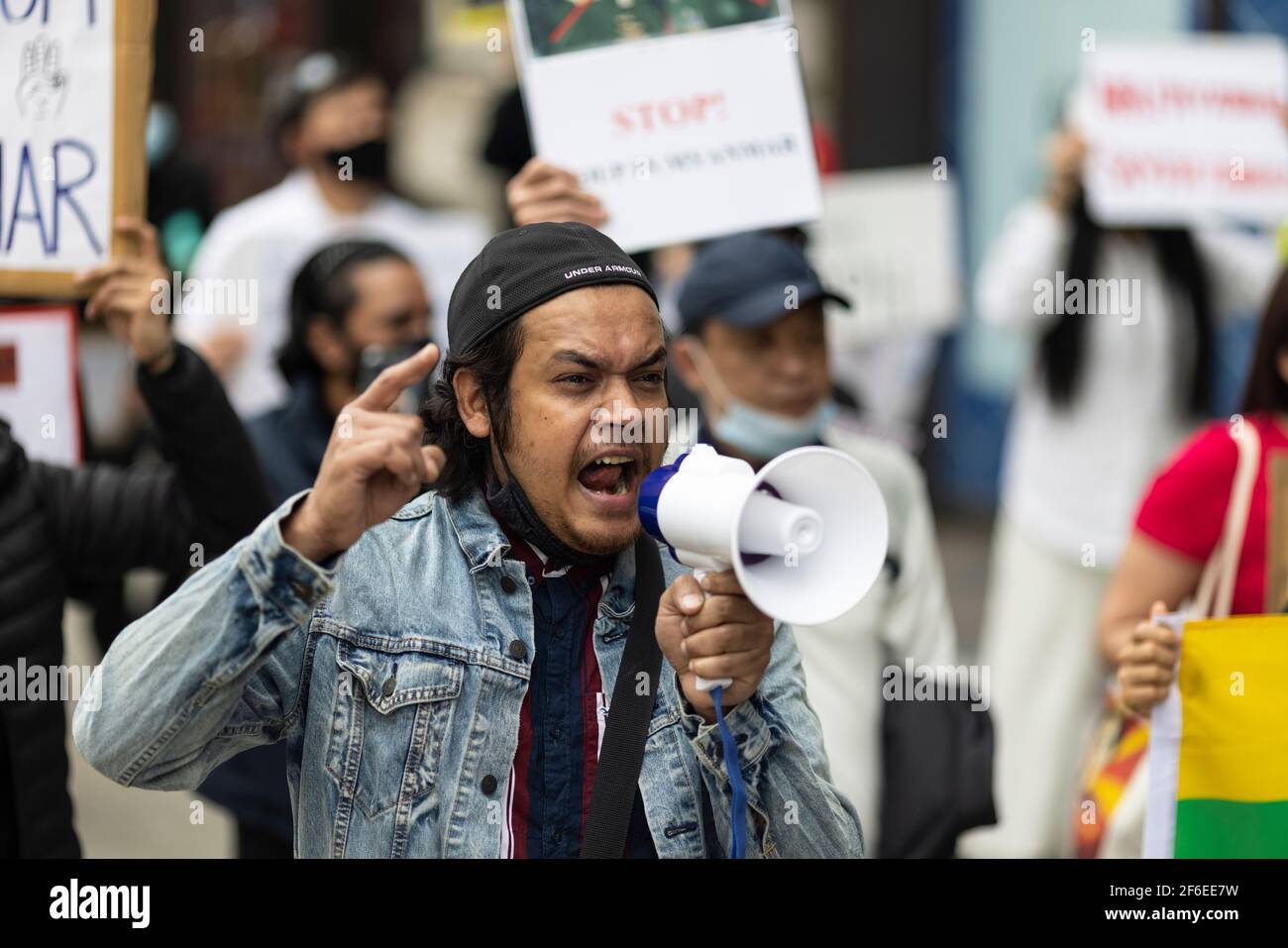 London, Großbritannien. März 2021, 31st. Ein marschierende Protestler, der in ein Megaphon schreit. Demonstranten versammelten sich auf dem Parliament Square - mit Gesichtsmasken und beobachteten eine soziale Distanzierung -, bevor sie zur chinesischen Botschaft marschierten, um Solidarität mit dem Volk von Myanmar gegen den Militärputsch und die staatlichen Tötungen von Zivilisten zu zeigen. Vor der Botschaft wurden Reden gehalten. Seit Beginn des Militärputsches am 1st. Februar wurden in Myanmar mehr als 520 Menschen von Sicherheitskräften getötet. Am vergangenen Samstag war der gewalttätigste Tag, an dem mehr als 100 Menschen getötet wurden. Kredit: Joshua Windsor/Alamy Live Nachrichten Stockfoto