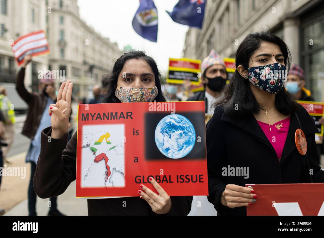 London, Großbritannien. März 2021, 31st. Ein marschierende Protestler grüßt mit drei Fingern den Widerstand und hält ein Plakat mit der Aufschrift "Myanmar ist ein globales Thema". Demonstranten versammelten sich auf dem Parliament Square - mit Gesichtsmasken und beobachteten eine soziale Distanzierung -, bevor sie zur chinesischen Botschaft marschierten, um Solidarität mit dem Volk von Myanmar gegen den Militärputsch und die staatlichen Tötungen von Zivilisten zu zeigen. Vor der Botschaft wurden Reden gehalten. Seit Beginn des Militärputsches am 1st. Februar wurden in Myanmar mehr als 520 Menschen von Sicherheitskräften getötet. Letzten Samstag war der gewalttätigste Tag, wenn Mo Stockfoto