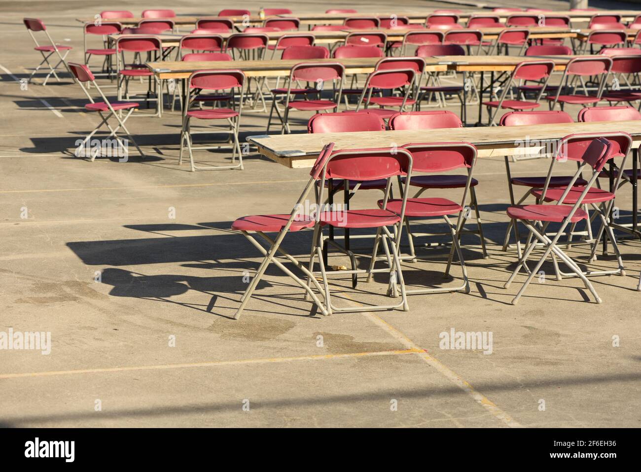 Mehrere Reihen von langen Klapptischen und roten Kunststoff-Falten Stühle auf einem Platz Stockfoto