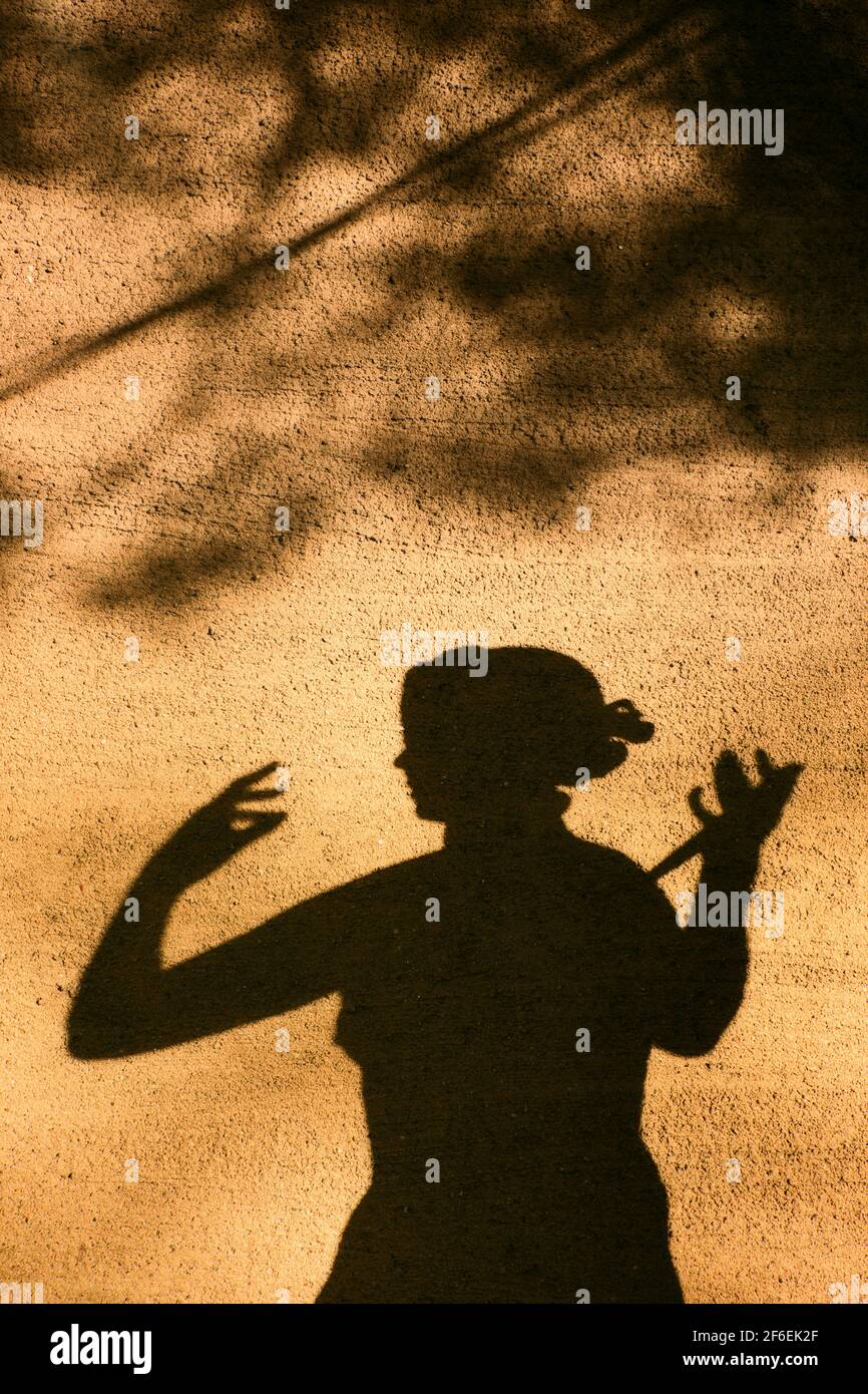 Schatten Silhouette Profil der weiblichen Statue auf texturierter Wand in Sonnenlicht. Konzept der Anonymität, unbekannt, nicht erkennbar Stockfoto