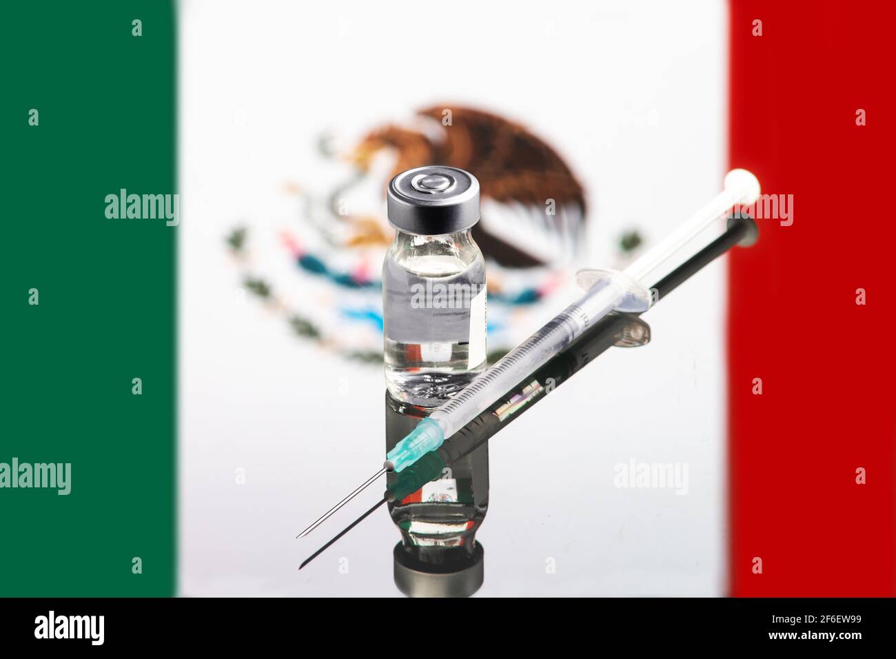 Impfkonzept mit reflektierter und entkoketer flagge mexikos, selektiver Fokus auf Impfstoff Stockfoto
