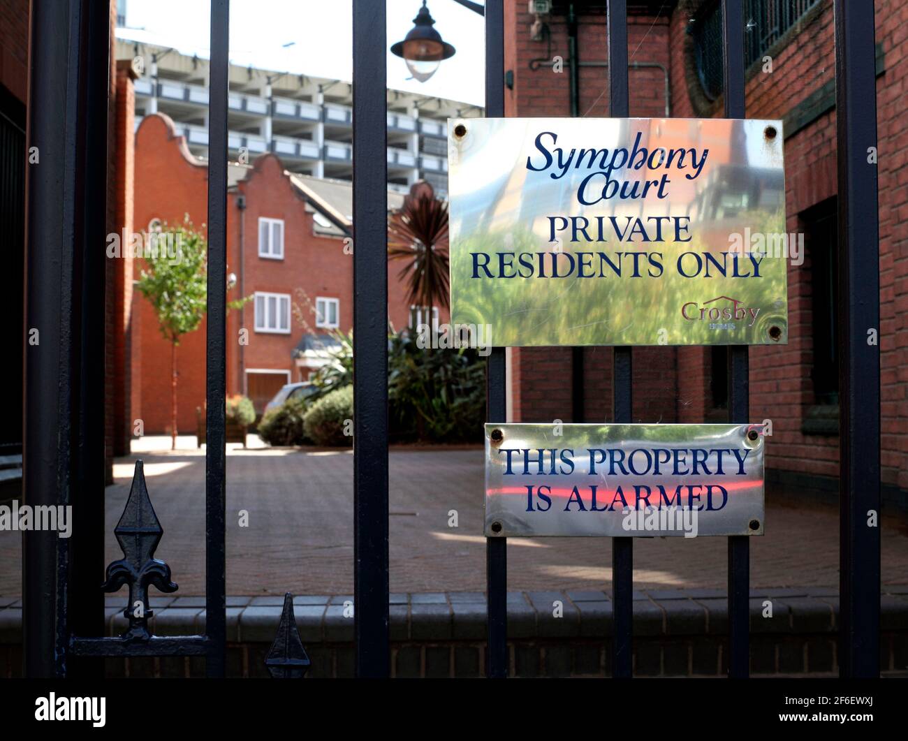 Hinweise auf einem eingezäunten Fußgängereingang zum Symphony Court, einem Wohnungssystem in der Nähe des Zentrums von Birmingham. Stockfoto