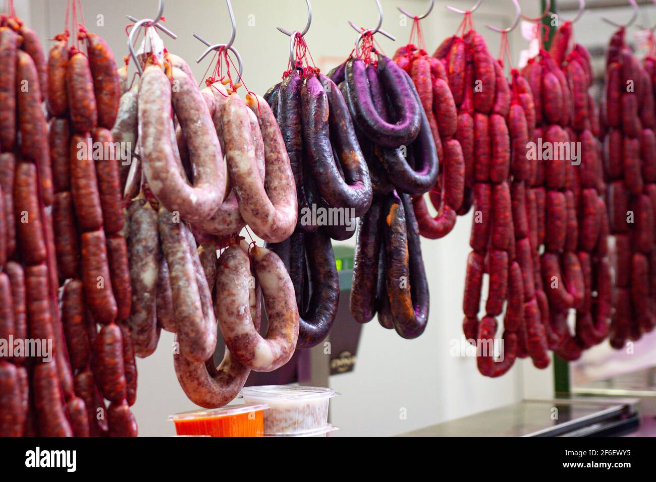 Verschiedene Wurstsorten hängen für eine Metzgerei-Ausstellung an Ein Hallenmarkt in Velez Malaga Stockfoto