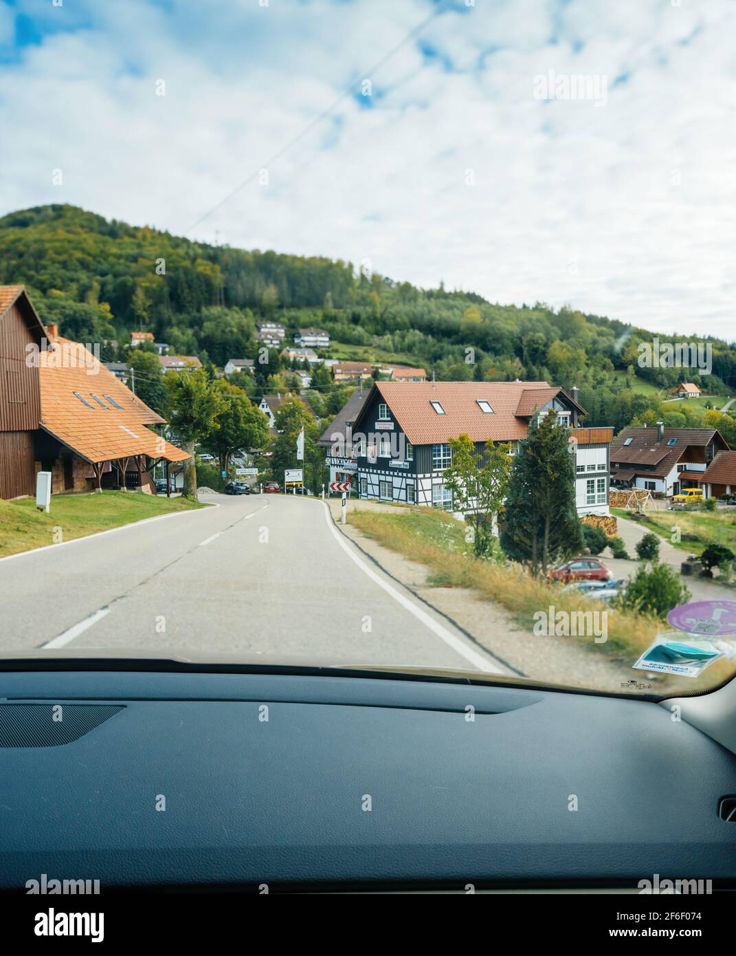 POV-Fahrerblick am Haupteingang des Dorfes Sasbachwalden In Baden-Württemberg mit mehrfachstämmig traditionellen deutschen Häusern und Gasthaus Bischenberg Stockfoto