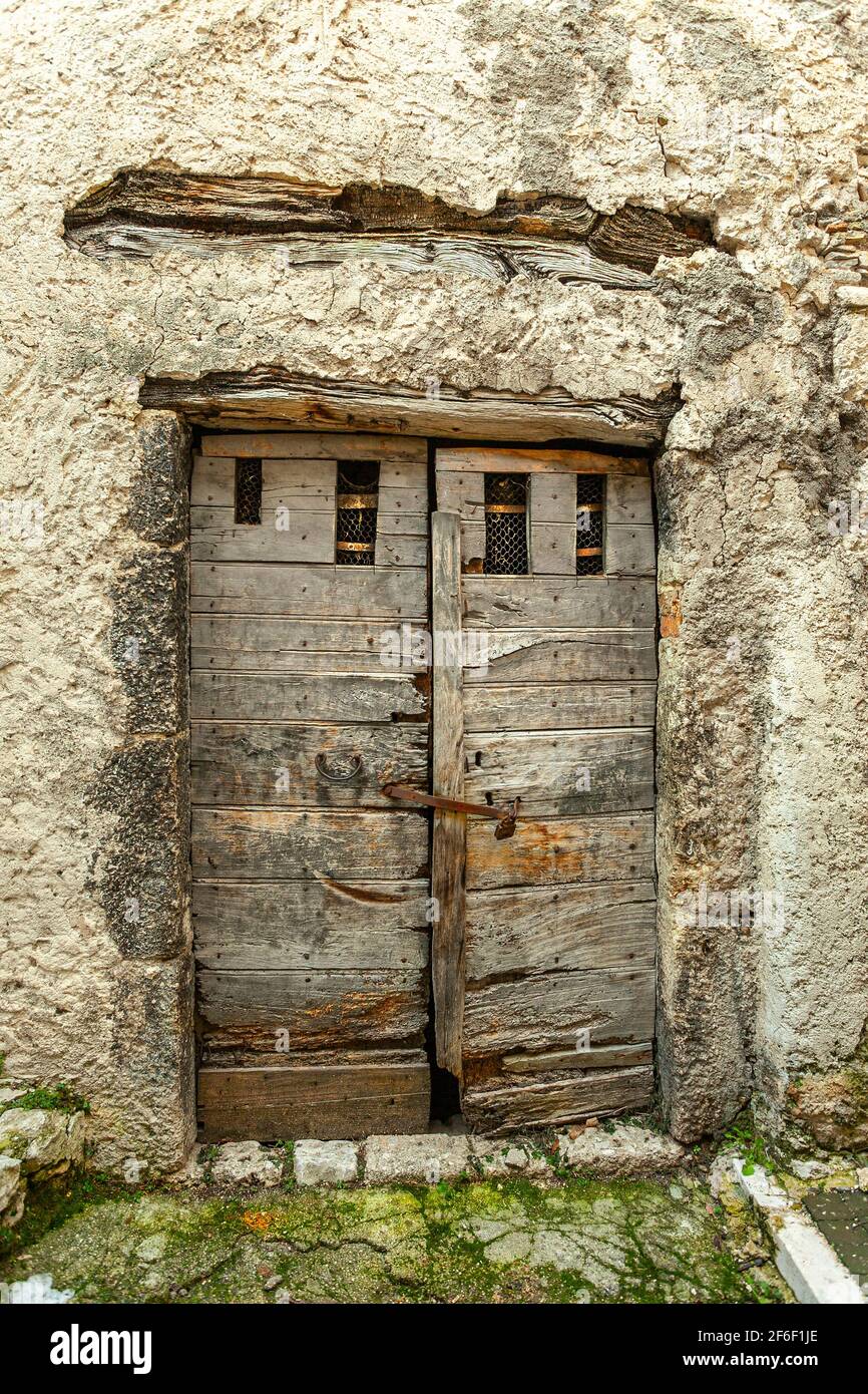Alter Eingang zu einem Steinhaus mit der Tür aus altem ruinierten Holz. Abruzzen, Italien, Europa Stockfoto