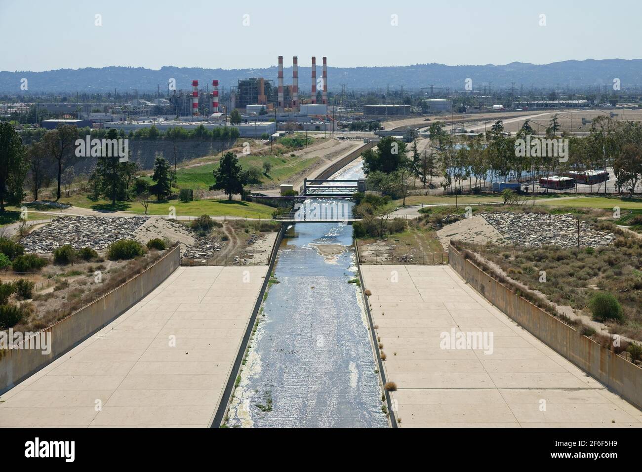 In Los Angeles, Kalifornien, wird der Tujunga Wash Waterway vom Hansen Dam aus gesehen, wobei ein mit Erdgas befeuerte Kraftwerk tagsüber im sichtbar ist Stockfoto