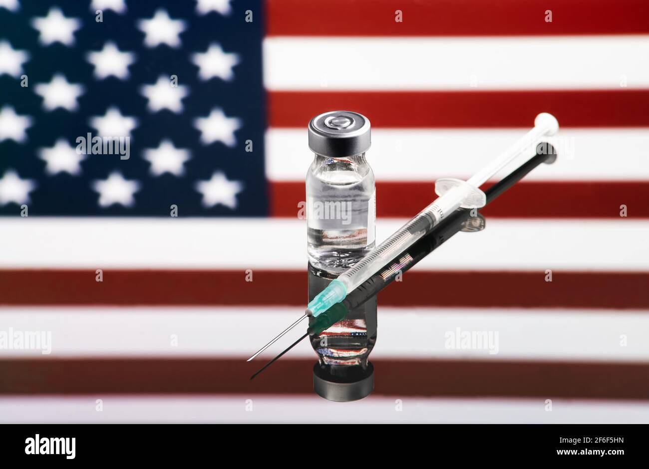Impfkonzept mit reflektierter und entkoketer eeuu-Länderflagge, selektiver Fokus auf Impfstoff Stockfoto