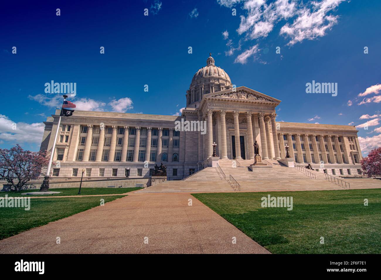 Niedriger Winkel Blick auf den Bürgersteig, der im Frühjahr zu dem mit Marmor verkleideten und säulenverkleideten Missouri State Capitol Gebäude in Jefferson City mit blauem Himmel führt. Stockfoto