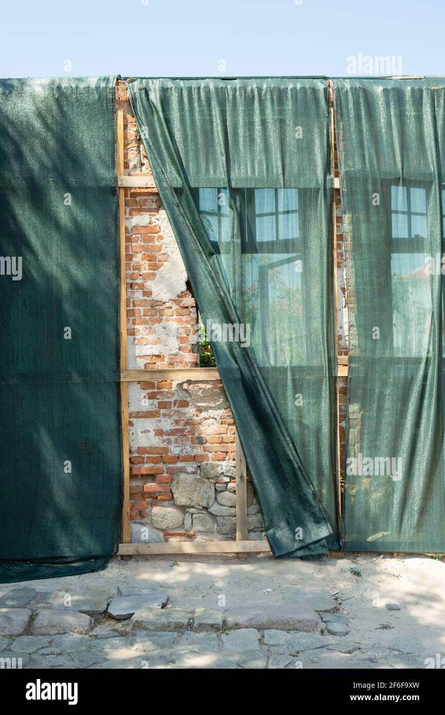 Fassade eines Gebäudes im Bau, mit grünem Stoff bedeckt, in der Altstadt von Plovdiv, Bulgarien Stockfoto