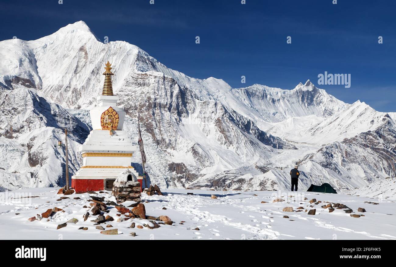 Blick auf die weiße buddhistische Stupa in der Nähe des Eissees (Kicho Tal) und der Annapurna Range, rund um den Annapurna Circuit Trekking Trail, Nepal Stockfoto