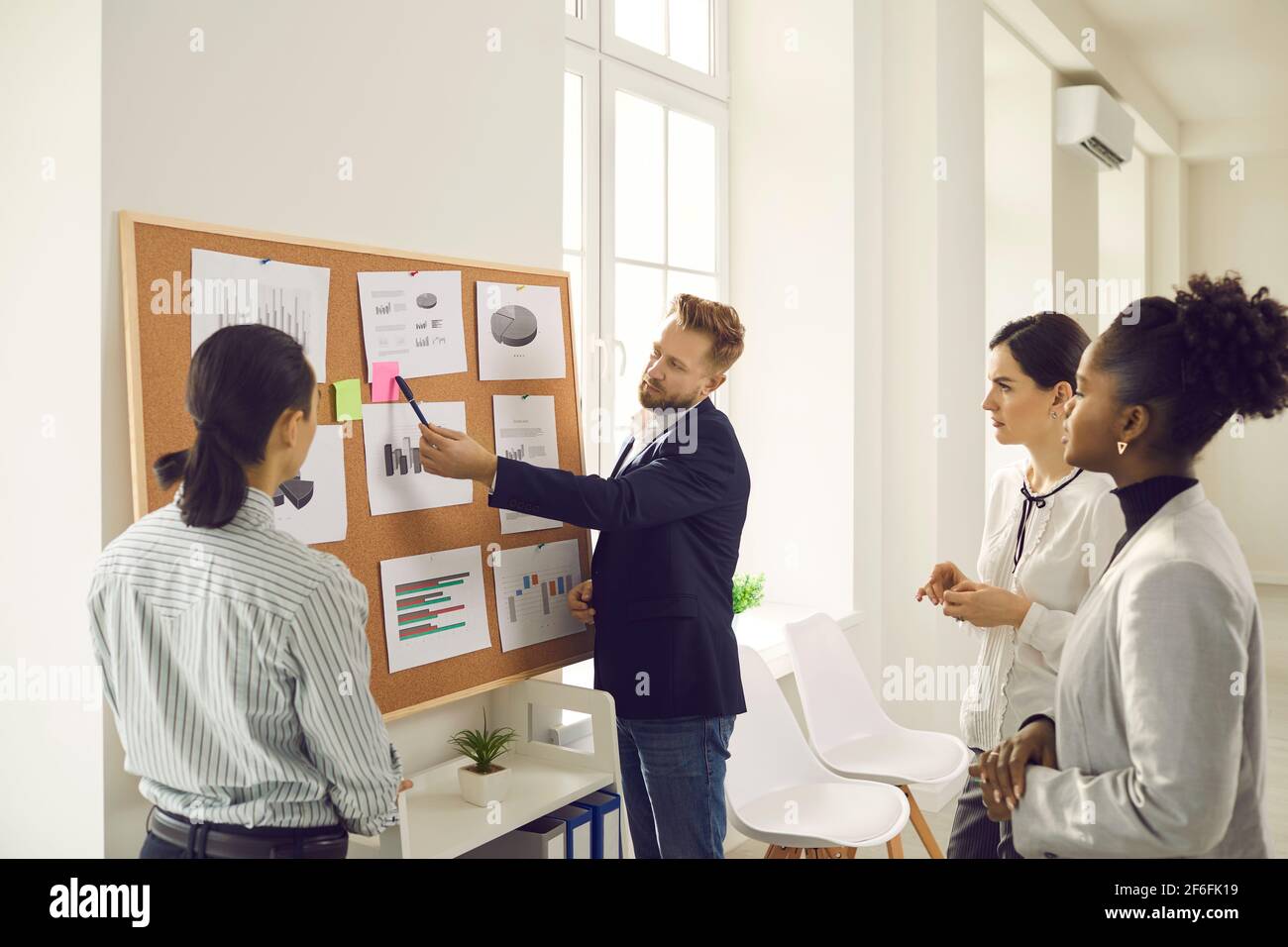 Eine Gruppe gemischter Büromitarbeiter steht und diskutiert Marketingentwicklungsstrategie Stockfoto