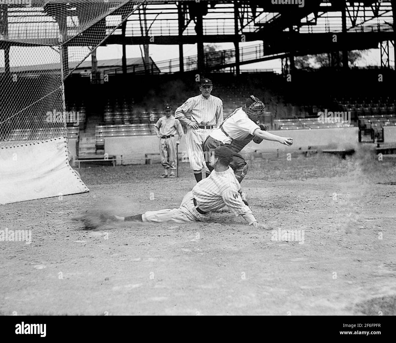 Der Baseballspielerin Ardis Yelton wird von Clyde Milan, Washington Senators, 10. Juni 1920, der richtige Weg gezeigt, um in eine Basis zu rutschen. Stockfoto