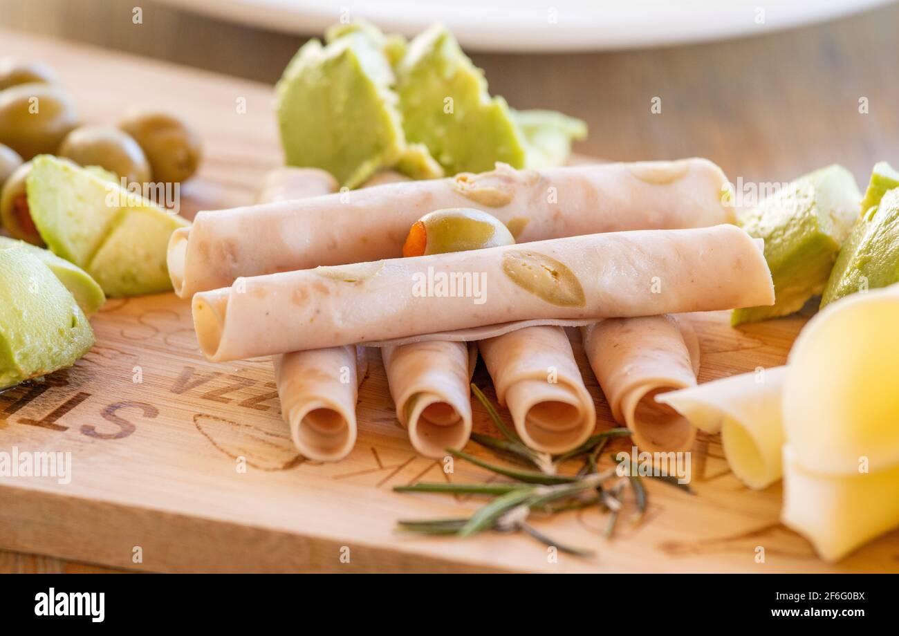 Nahaufnahme von Schinken und Käse, auf Holzbrett, serviert am Tisch. Stockfoto