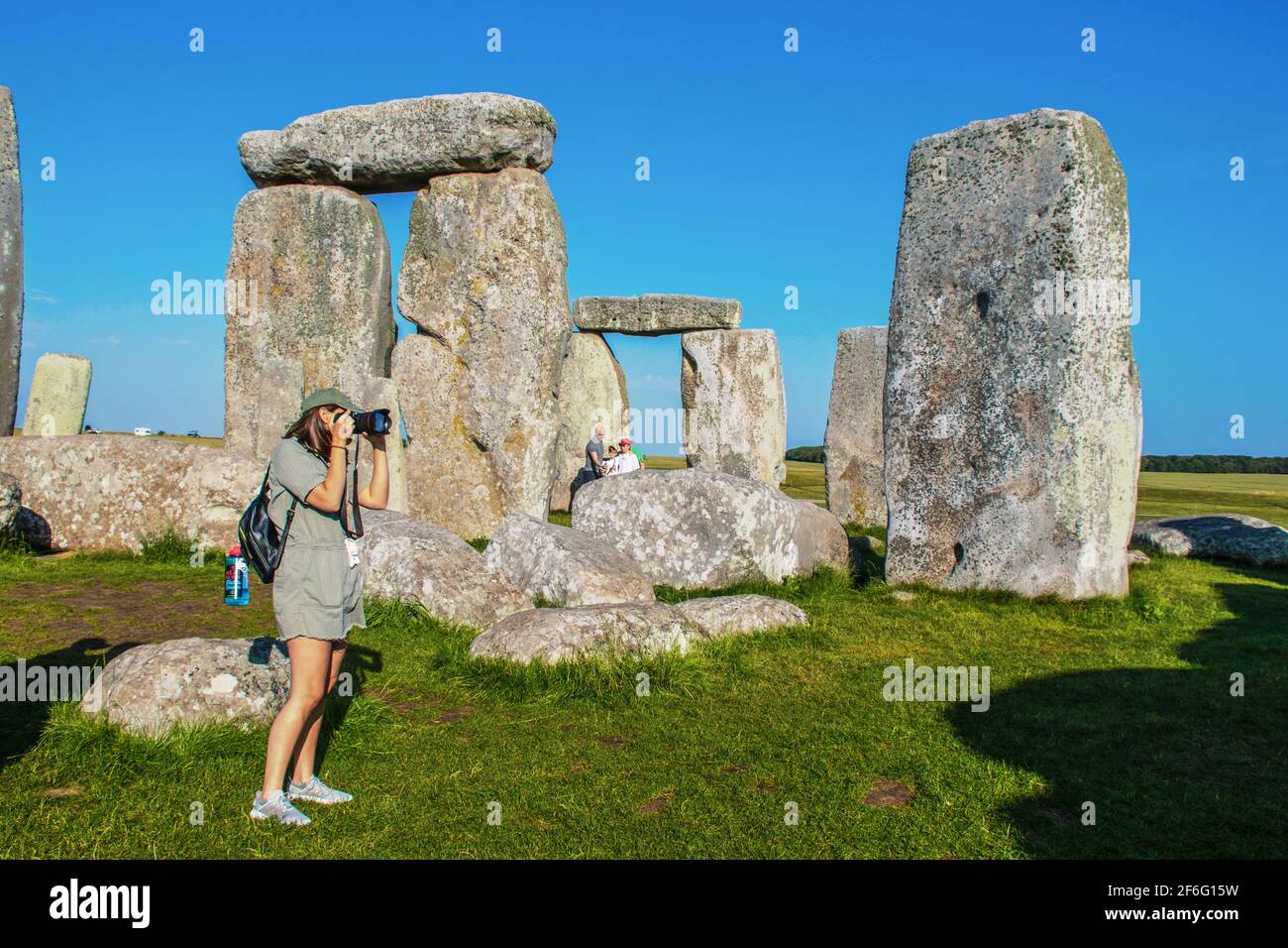 Juli 25 2019 Stonehenge UK Fotografin in Shorts nimmt Ein Bild in den stehenden Steinen in Stonehenge während des Vaters Nimmt Selfie mit dem Telefon auf Stockfoto
