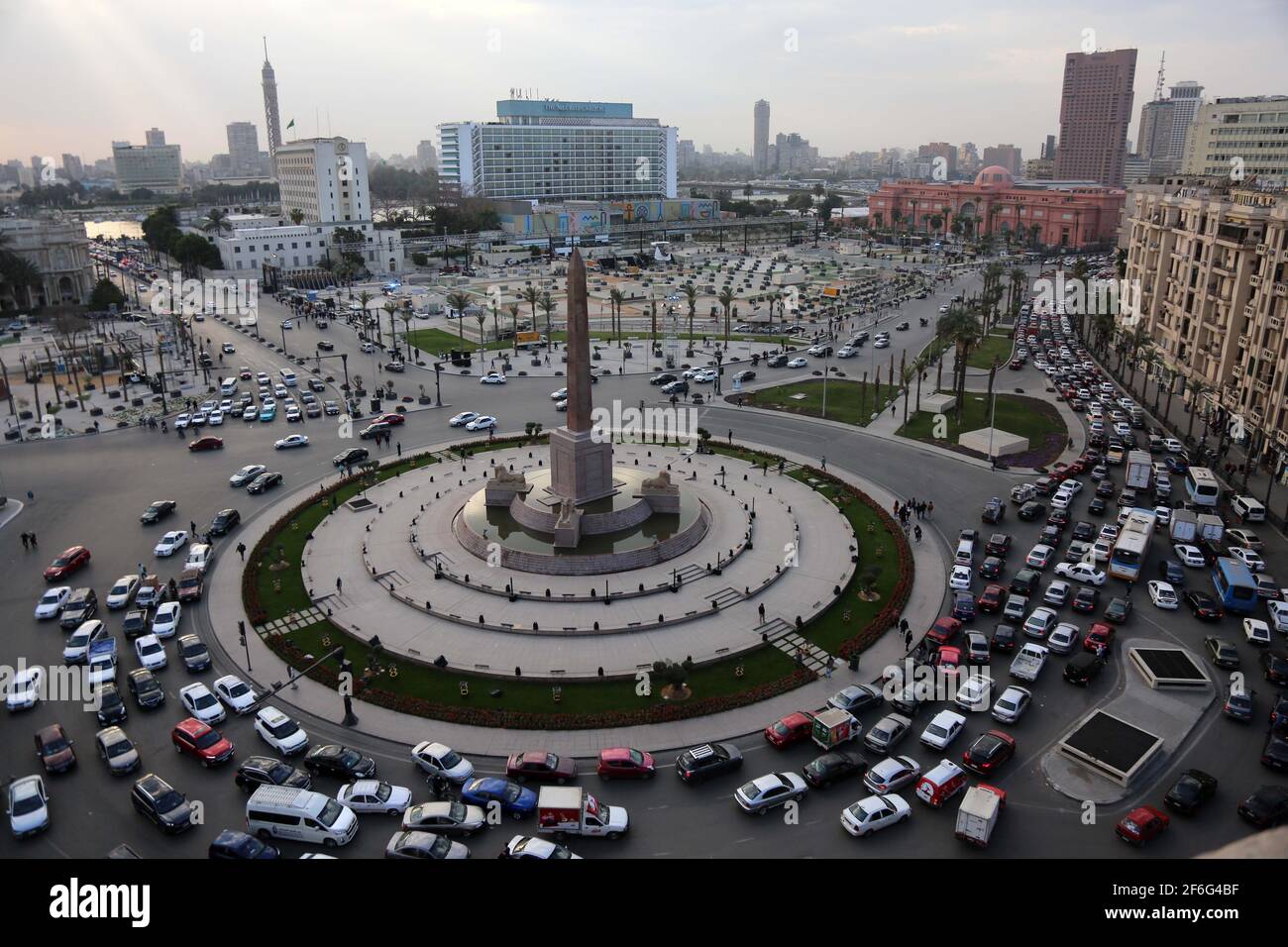 31. März 2021, Ägypten, Kairo: Eine allgemeine Ansicht des El-Tahrir-Platzes mit Fahrzeugen, die durch den Hauptumkreisel fahren, geschmückt mit den Obelisken von Ramses II und Rams Statuen. Nach Angaben des ägyptischen Ministeriums für Tourismus und Altertümer werden 22 Mumien vom Ägyptischen Museum in Tahrir zum Nationalen Museum der ägyptischen Zivilisation in Fustat gebracht. Die Mumien, die übertragen werden, gehören Pharao Ramses II; Pharao Ramses IX; Pharao Ramses VI; Pharao Ramses V; Pharao Seti I; Pharao Seqenenre; und Pharao Thutmose III, sowie Königin Hatschepsut; Königin Meritamun, die Frau von Stockfoto