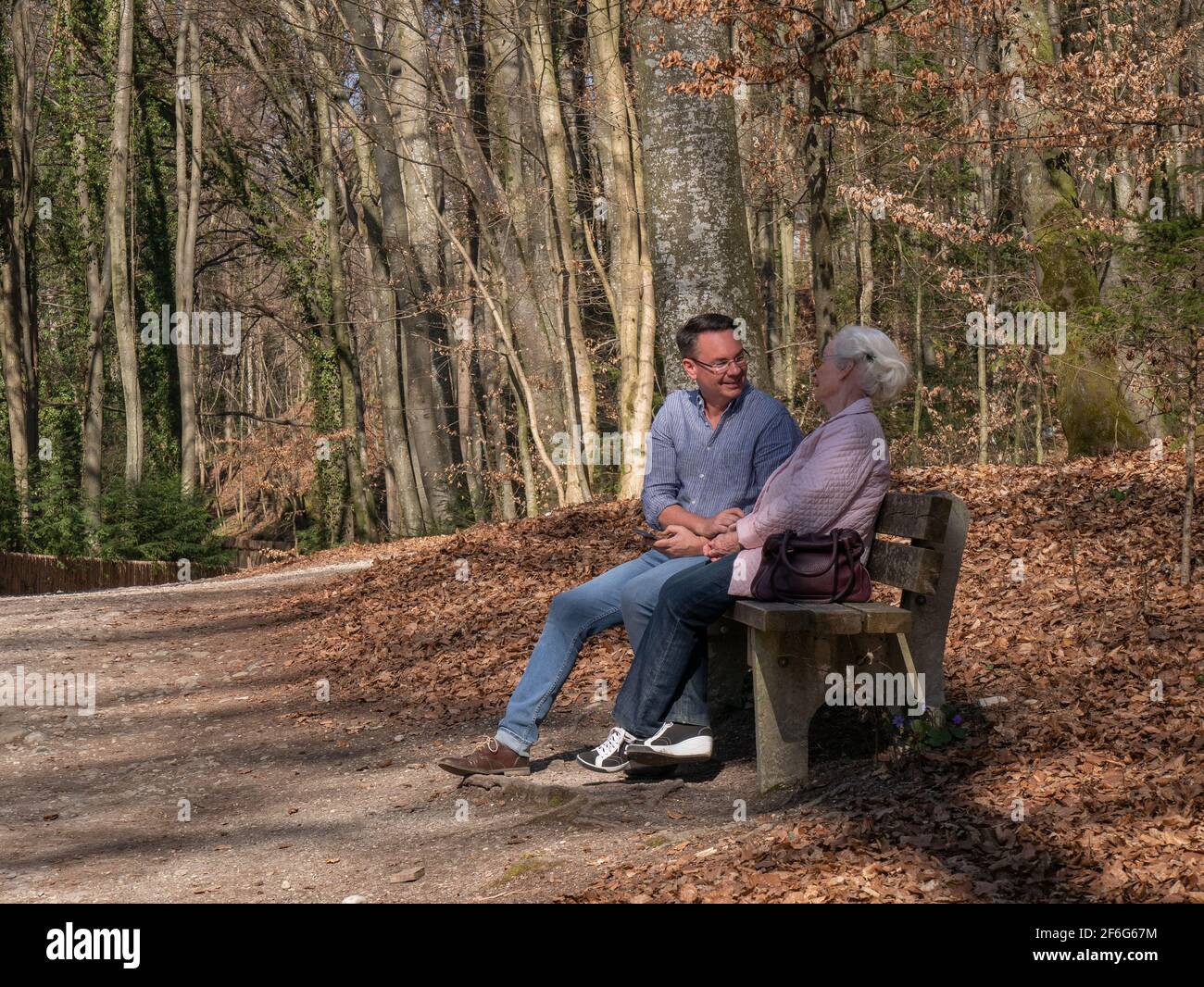 Ältere Mutter und ihr Sohn sitzen im Park Stockfoto