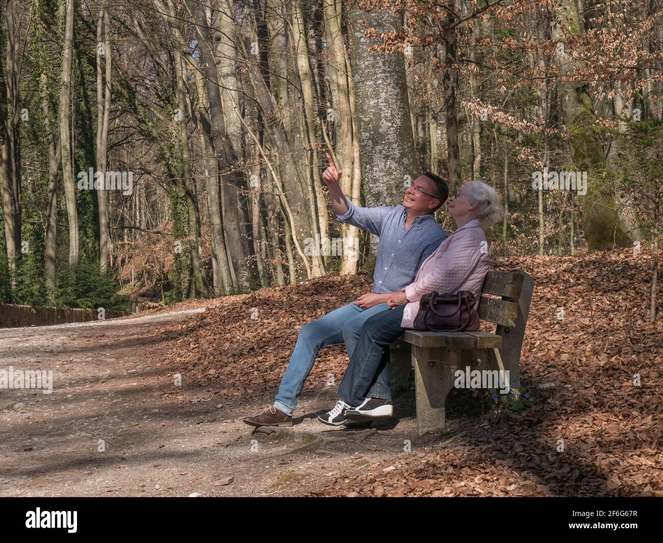 Ältere Mutter und ihr Sohn sitzen im Park Stockfoto