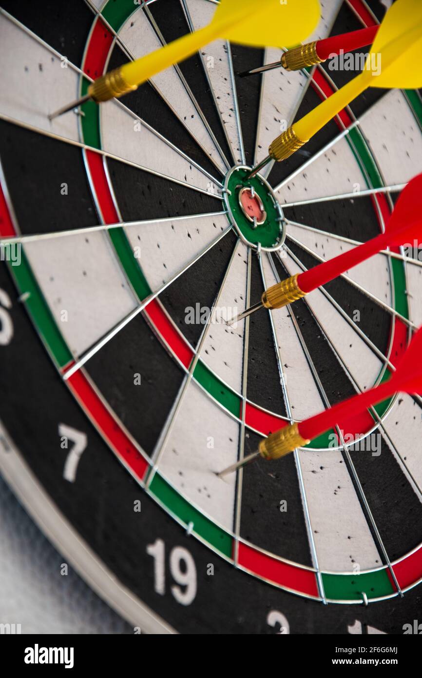 Datboard und einige bunte Darts für weniger Zeit auf verwendet Ein weißer Tisch Stockfoto