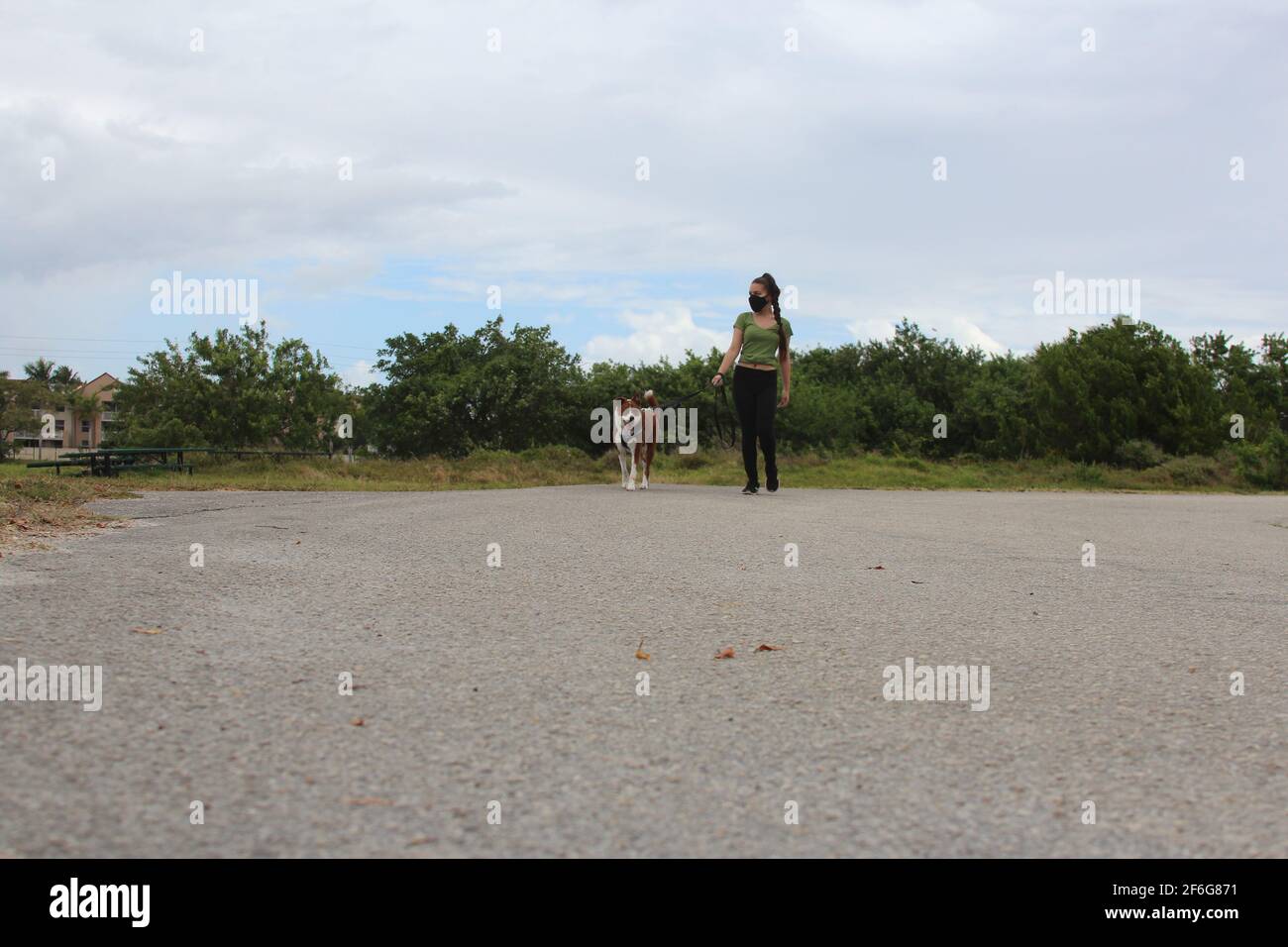 Frau läuft mit ihrem Hund in der neuen Normalität Stockfoto