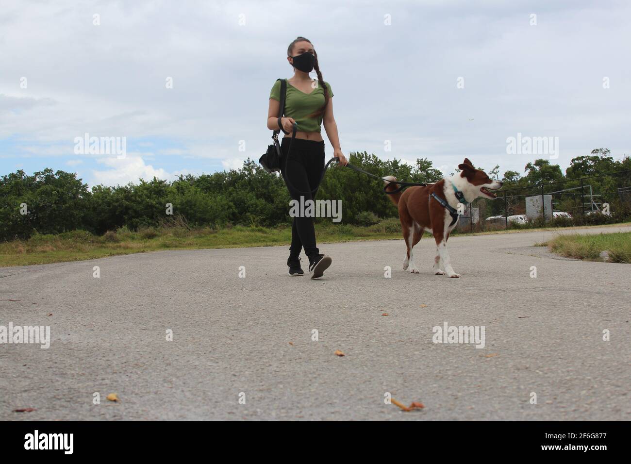 Frau läuft mit ihrem Hund in der neuen Normalität Stockfoto