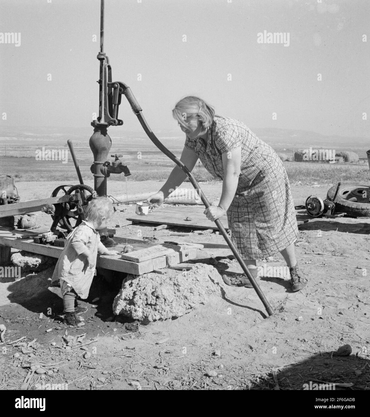 Frau Soper mit dem jüngsten Kind am Brunnen. Willow Creek Area, Malheur County, Oregon. 1939. Foto von Dorothea lange. Stockfoto
