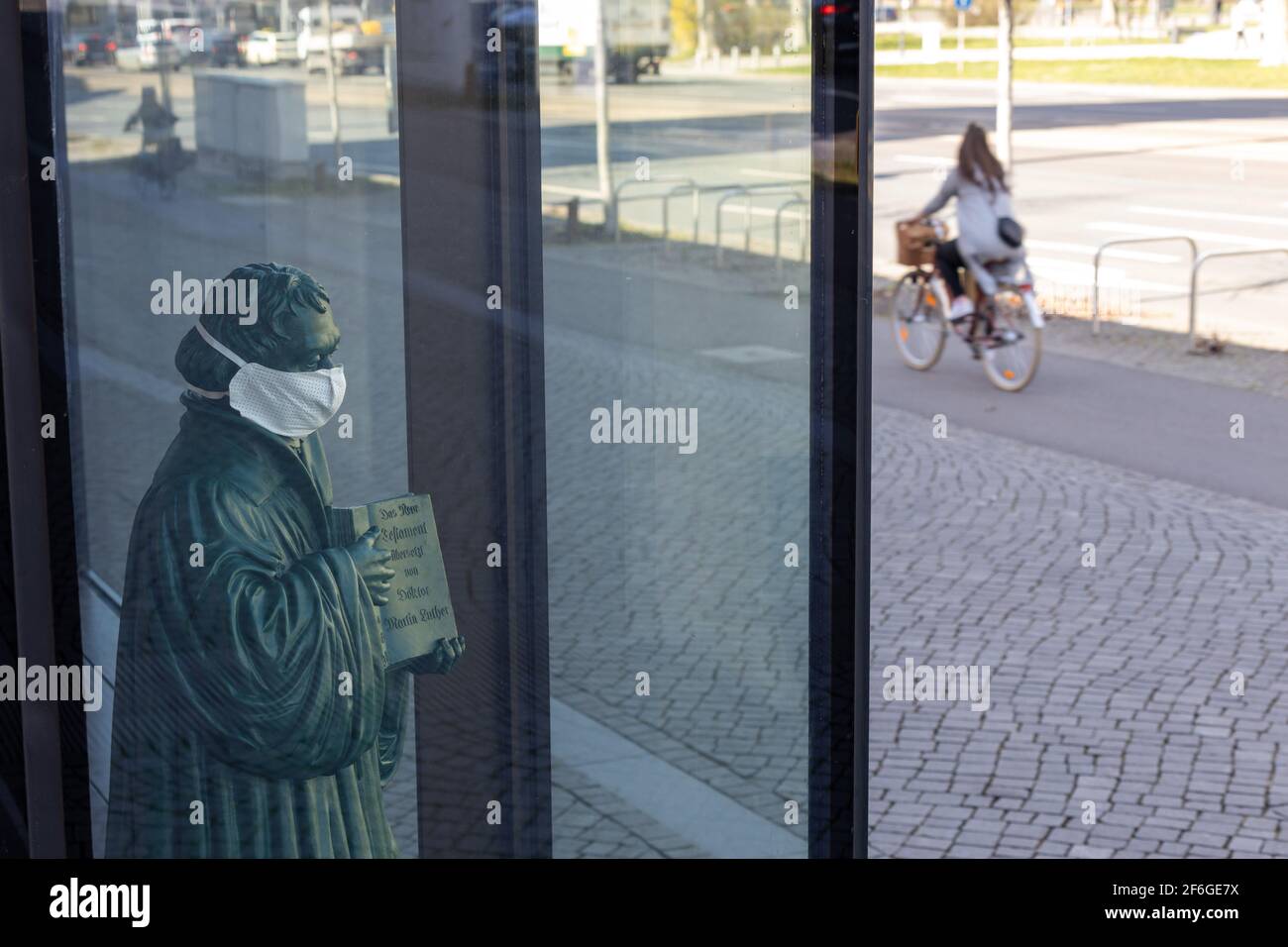 Leipzig, Sachsen, Deutschland; 03-31-2021 STATUE des Reformators Martin Luther mit Mund- und Nasenschutz im Schaufenster einer Kirche Stockfoto
