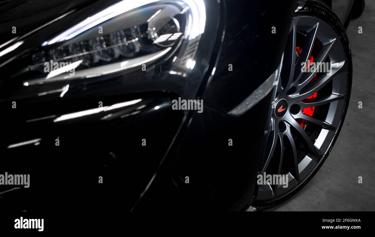Das vordere Diamantschliff-Rad eines schwarzen McLaren 2017 570GT mit roten Bremssättel Stockfoto
