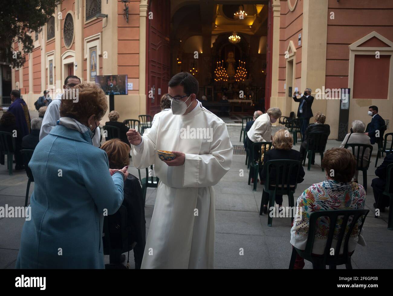 Während der Karwoche haben Gläubige die heilige Kommunion außerhalb der Bruderschaft La Paloma.Trotz der Absage der Karwoche Prozessionen, viele Bruderschaften haben beschlossen, Messen, Verehrung und Ausstellung Figuren von Christus und der Jungfrau heiraten in Kirchen nach allen Schutzmaßnahmen gegen Covid19. Stockfoto