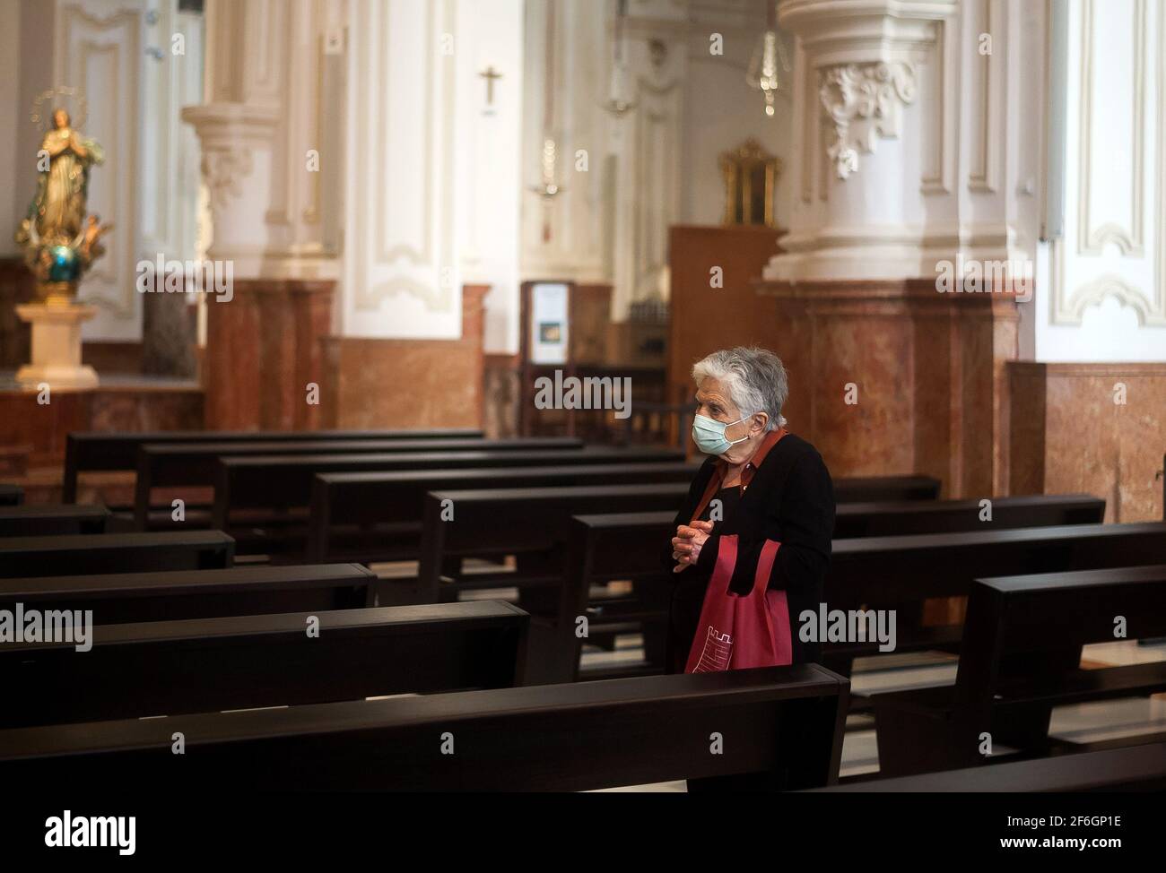 Eine ältere Frau, die während der Karwoche in der Kirche von Santiago gesehen wurde.Trotz der Absage der Karwoche haben viele Bruderschaften beschlossen, Messen, Verehrung und die Ausstellung von Figuren von Christus und der Jungfrau, mit denen sie heiraten, in Kirchen zu organisieren, nachdem alle Schutzmaßnahmen gegen Covid19 ergriffen wurden. Stockfoto