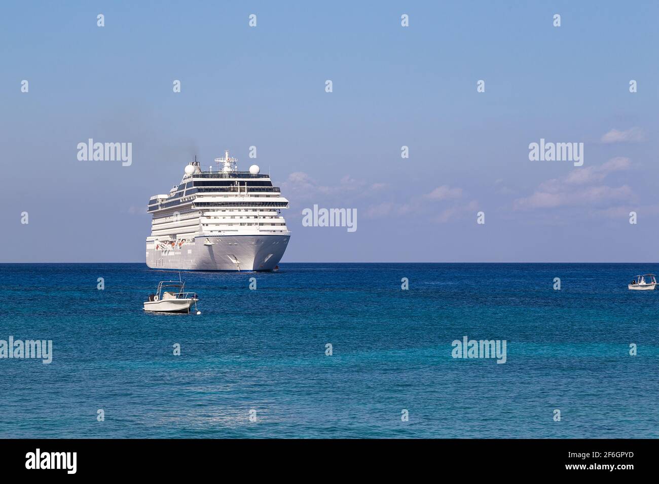 Großes, wunderschönes Luxuskreuzfahrtschiff am karibischen Meer, mit blauem Himmel und weißen Wolken im Hintergrund. Stockfoto