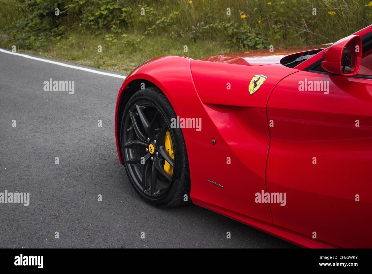 Die Front EINES Red 2015 Ferrari F12 Berlinetta mit Gloss Grey Front Wheel Emblem Am Vorderrad Mit Gelber Bremssattel Stockfoto