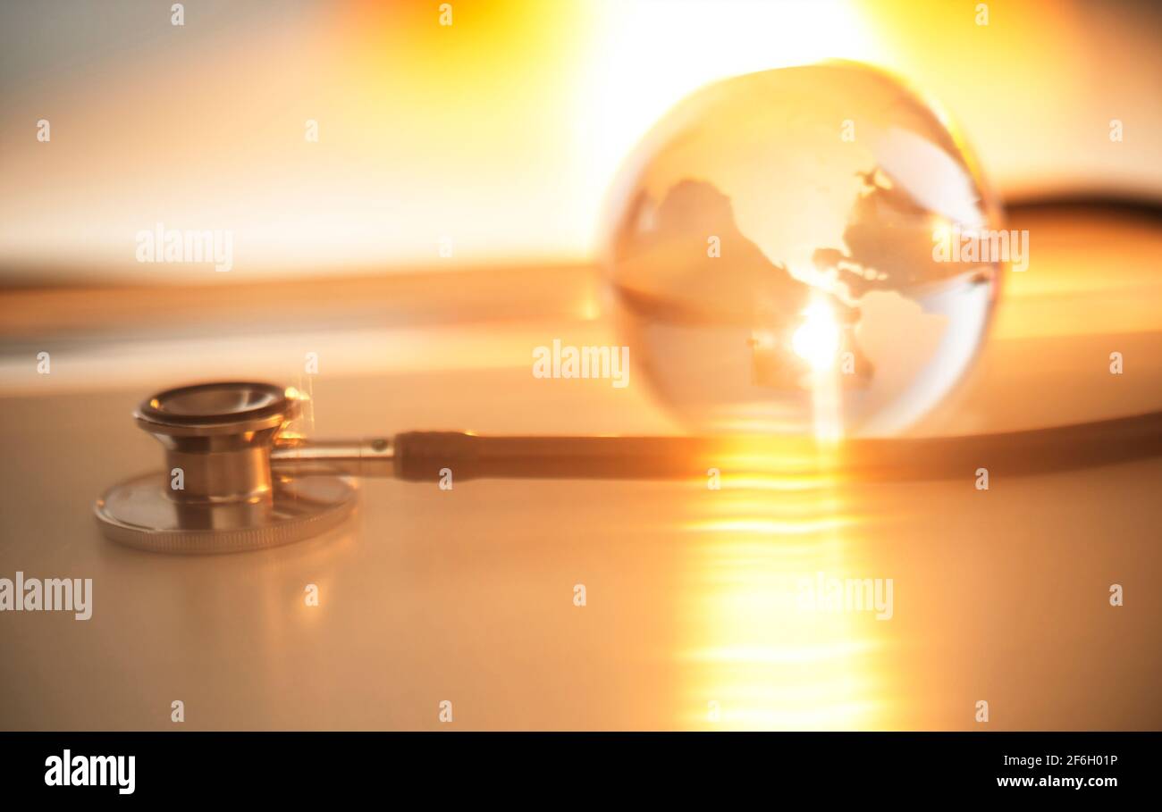Stethoskop und Kristallkugel mit Hintergrund aus goldenem Licht Stockfoto