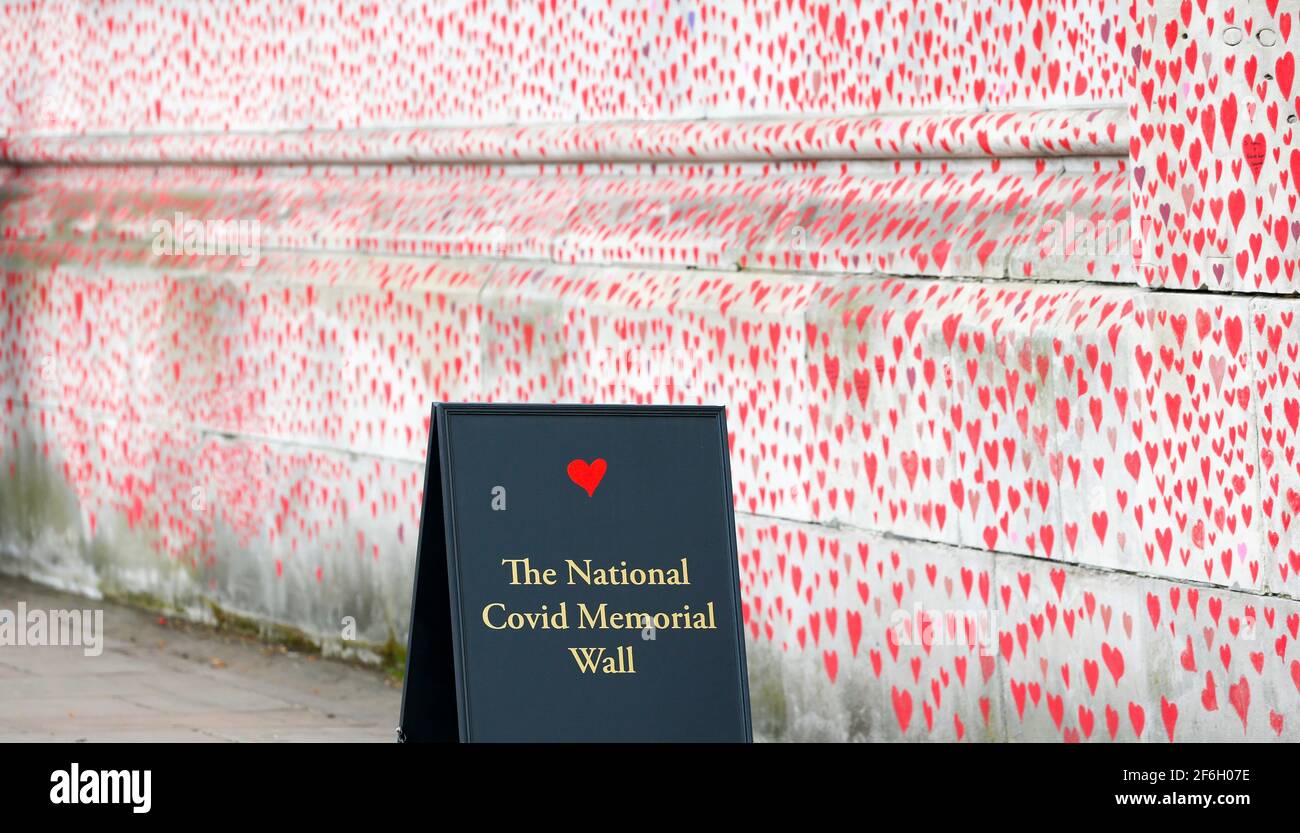 London, Großbritannien. März 2021. Das am 31. März 2021 aufgenommene Foto zeigt die National COVID Memorial Wall in London, Großbritannien. Trauerliche Familienmitglieder und Freiwillige sind dabei, Herzen entlang einer halben Meile Mauer gegenüber dem Houses of Parliament in London zu malen, um an diejenigen zu erinnern, die an COVID-19 gestorben sind. Weitere 4,052 Menschen in Großbritannien testeten COVID-19 positiv, was die Gesamtzahl der Coronavirus-Fälle im Land auf 4,345,788 brachte, laut offiziellen Zahlen, die am Mittwoch veröffentlicht wurden. Quelle: Han Yan/Xinhua/Alamy Live News Stockfoto