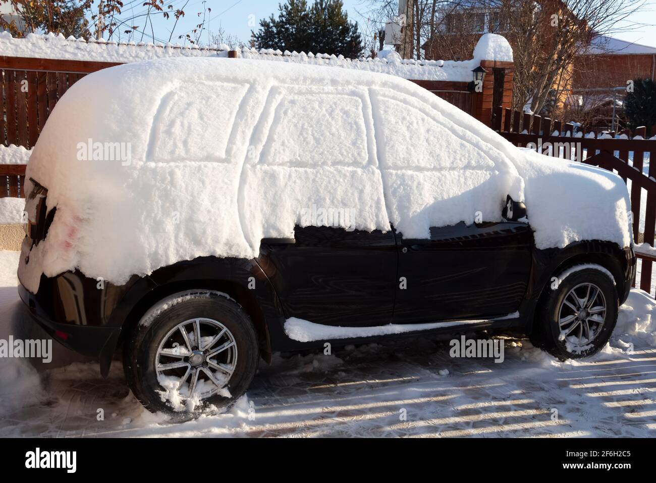 Ein Auto, das nach einem Schneesturm komplett mit dickem Schnee