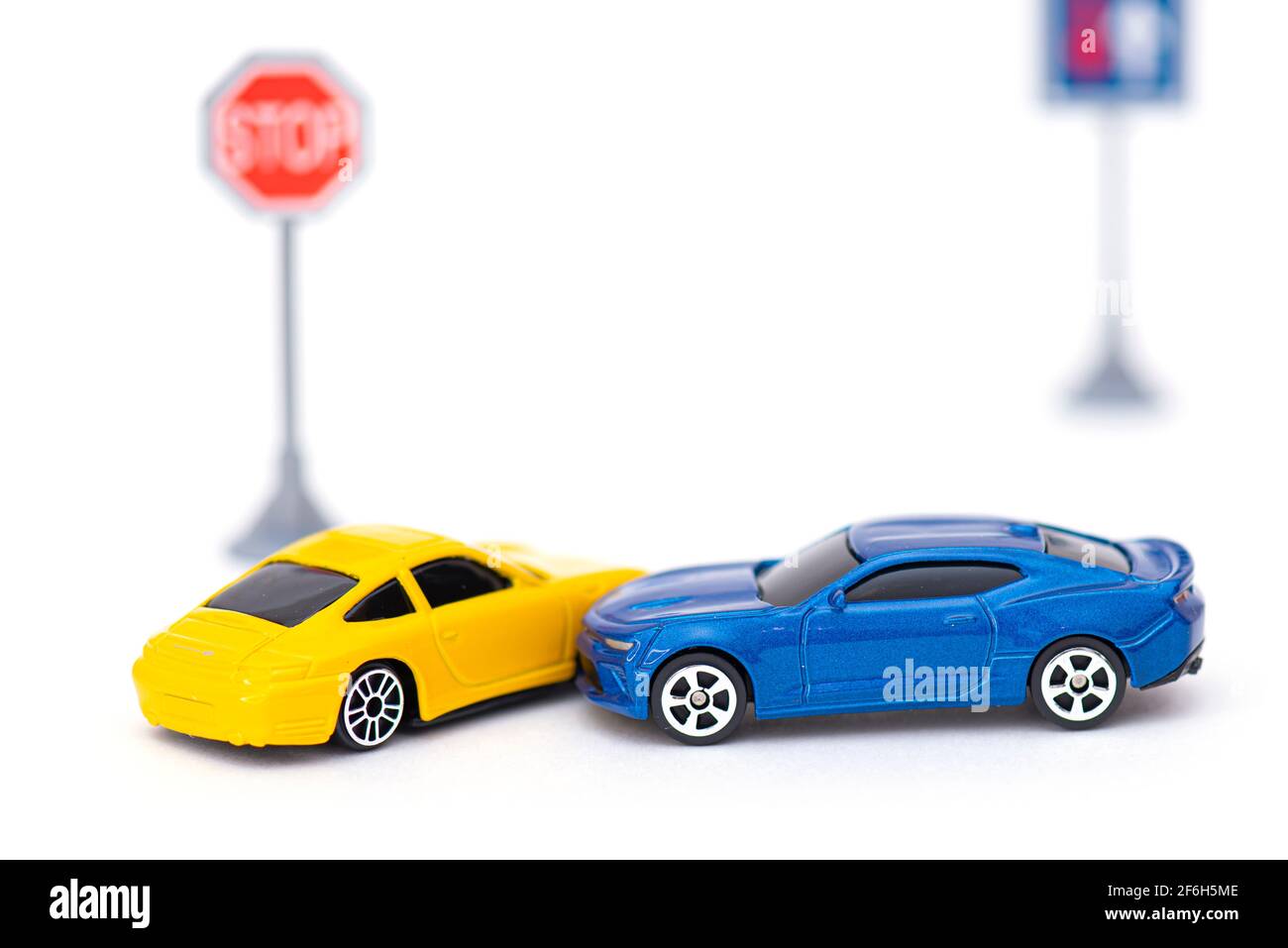 Unfall mit zwei Spielzeugautos und Schild auf weiß isoliert. Konzeptbild über Unfall auf der Straße Stockfoto