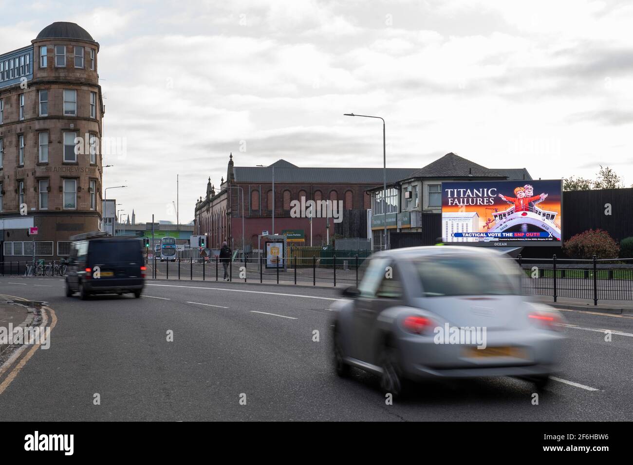 Glasgow, Schottland, Großbritannien. April 2021. IM BILD: Eine riesige elektronische Plakatwand, auf der eine Grafik mit dem Titel „TITANIC FAILURES“ und „TACTICAL VOTEE THE SNP OUT“ abgebildet ist, mit Comic-Figuren von Nicola Sturgeon und Alex Salmond, die die berühmte Szene aus dem Titanic am Bug nachspielen, aber stattdessen auf der Fähre von Glen Alba. Pressemitteilung Link: https://www.scotlandmatters.co.uk/titanicfailurebillboard/ Artikel Link: https://www.bbc.co.uk/news/amp/uk-scotland-glasgow-west-56579158?  twitter impression=true&s=03 Quelle: Colin Fisher/Alamy Live News. Stockfoto