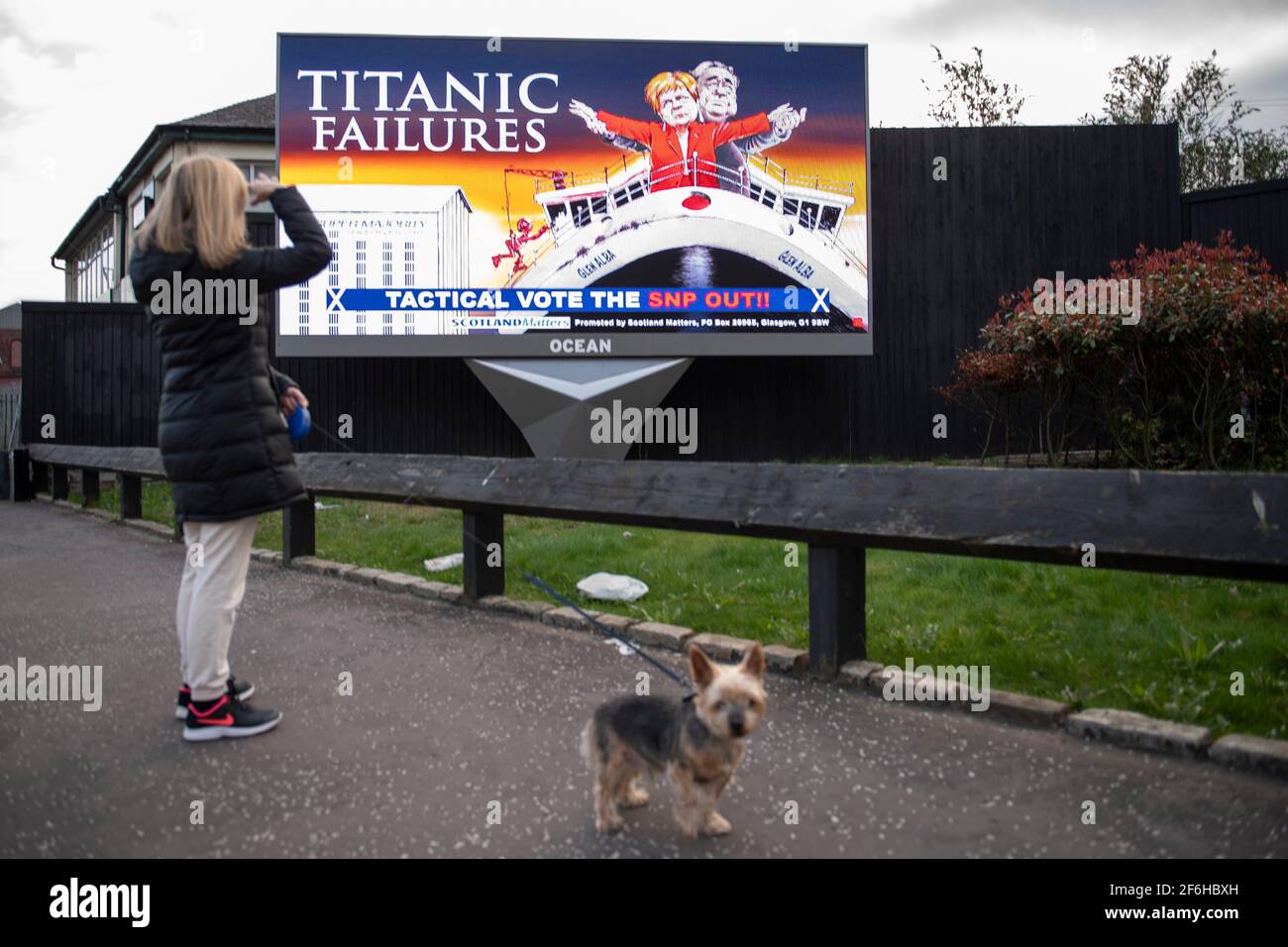 Glasgow, Schottland, Großbritannien. April 2021. IM BILD: Eine riesige elektronische Plakatwand, auf der eine Grafik mit dem Titel „TITANIC FAILURES“ und „TACTICAL VOTEE THE SNP OUT“ abgebildet ist, mit Comic-Figuren von Nicola Sturgeon und Alex Salmond, die die berühmte Szene aus dem Titanic am Bug nachspielen, aber stattdessen auf der Fähre von Glen Alba. Pressemitteilung Link: https://www.scotlandmatters.co.uk/titanicfailurebillboard/ Artikel Link: https://www.bbc.co.uk/news/amp/uk-scotland-glasgow-west-56579158?  twitter impression=true&s=03 Quelle: Colin Fisher/Alamy Live News. Stockfoto