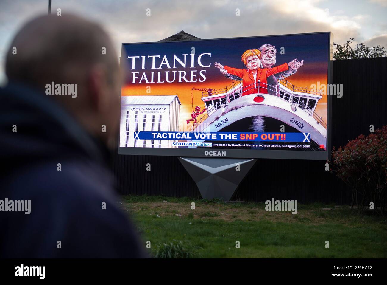 Glasgow, Schottland, Großbritannien. April 2021. IM BILD: Eine riesige elektronische Plakatwand, auf der eine Grafik mit dem Titel „TITANIC FAILURES“ und „TACTICAL VOTEE THE SNP OUT“ abgebildet ist, mit Comic-Figuren von Nicola Sturgeon und Alex Salmond, die die berühmte Szene aus dem Titanic am Bug nachspielen, aber stattdessen auf der Fähre von Glen Alba. Pressemitteilung Link: https://www.scotlandmatters.co.uk/titanicfailurebillboard/ Artikel Link: https://www.bbc.co.uk/news/amp/uk-scotland-glasgow-west-56579158?  twitter impression=true&s=03 Quelle: Colin Fisher/Alamy Live News. Stockfoto