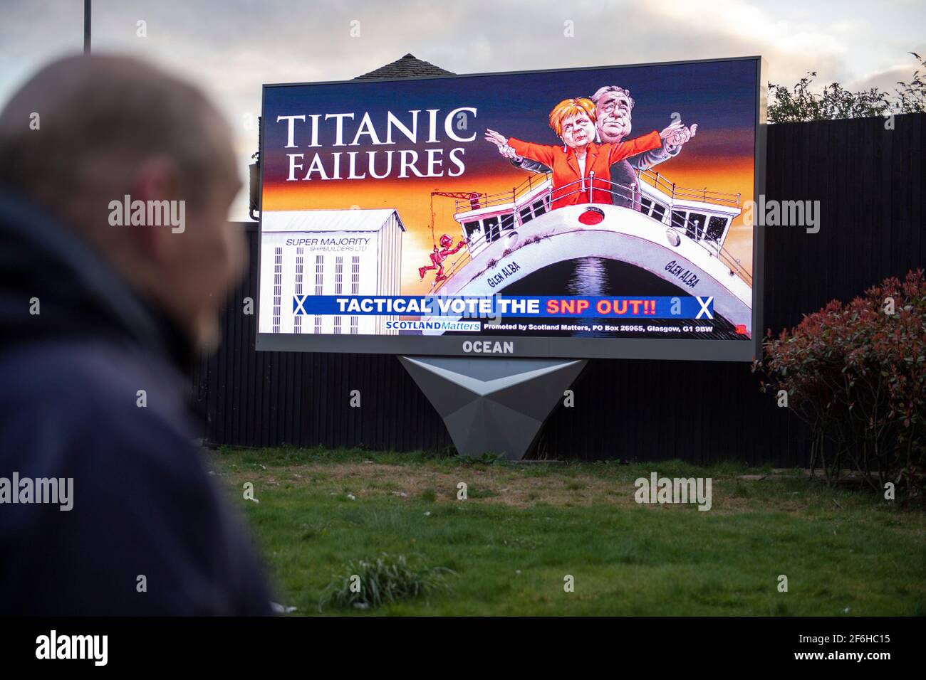 Glasgow, Schottland, Großbritannien. April 2021. IM BILD: Eine riesige elektronische Plakatwand, auf der eine Grafik mit dem Titel „TITANIC FAILURES“ und „TACTICAL VOTEE THE SNP OUT“ abgebildet ist, mit Comic-Figuren von Nicola Sturgeon und Alex Salmond, die die berühmte Szene aus dem Titanic am Bug nachspielen, aber stattdessen auf der Fähre von Glen Alba. Pressemitteilung Link: https://www.scotlandmatters.co.uk/titanicfailurebillboard/ Artikel Link: https://www.bbc.co.uk/news/amp/uk-scotland-glasgow-west-56579158?  twitter impression=true&s=03 Quelle: Colin Fisher/Alamy Live News. Stockfoto